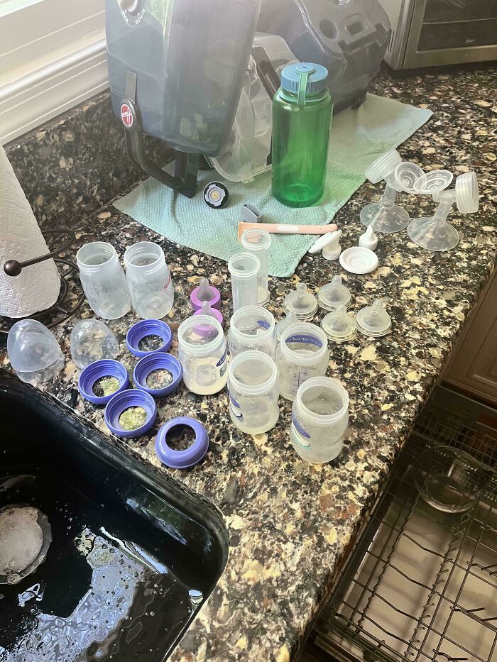 A kitchen counter filled with baby bottles, nipples, and pump parts, showcasing the wholesome and fun side of being a dad.