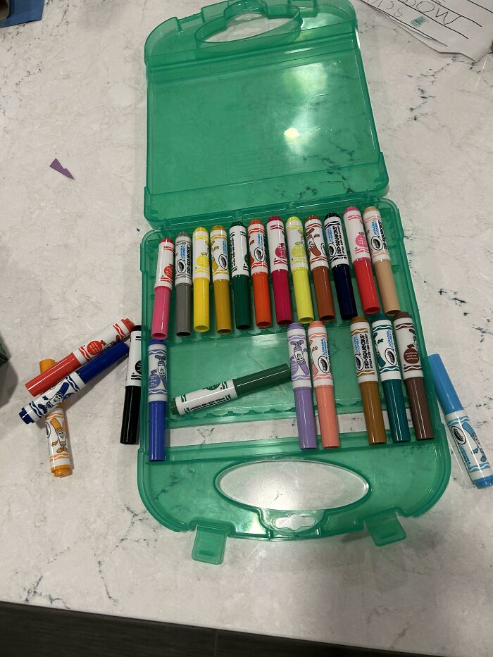 Various colorful markers scattered around an open green case, illustrating the wholesome and fun side of being a dad.