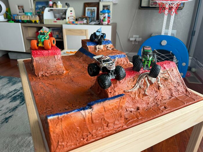 A creative diorama with monster trucks on a custom terrain, exemplifying the wholesome and fun side of being a dad.