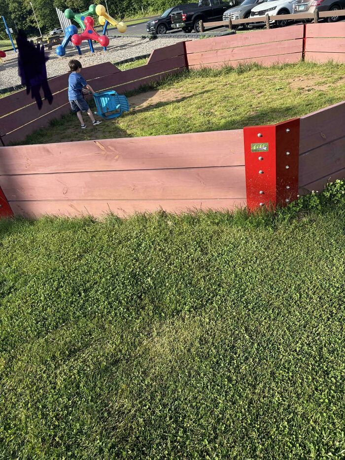 A young boy playing in a sandbox at a playground, showcasing a wholesome and fun side of being a dad.