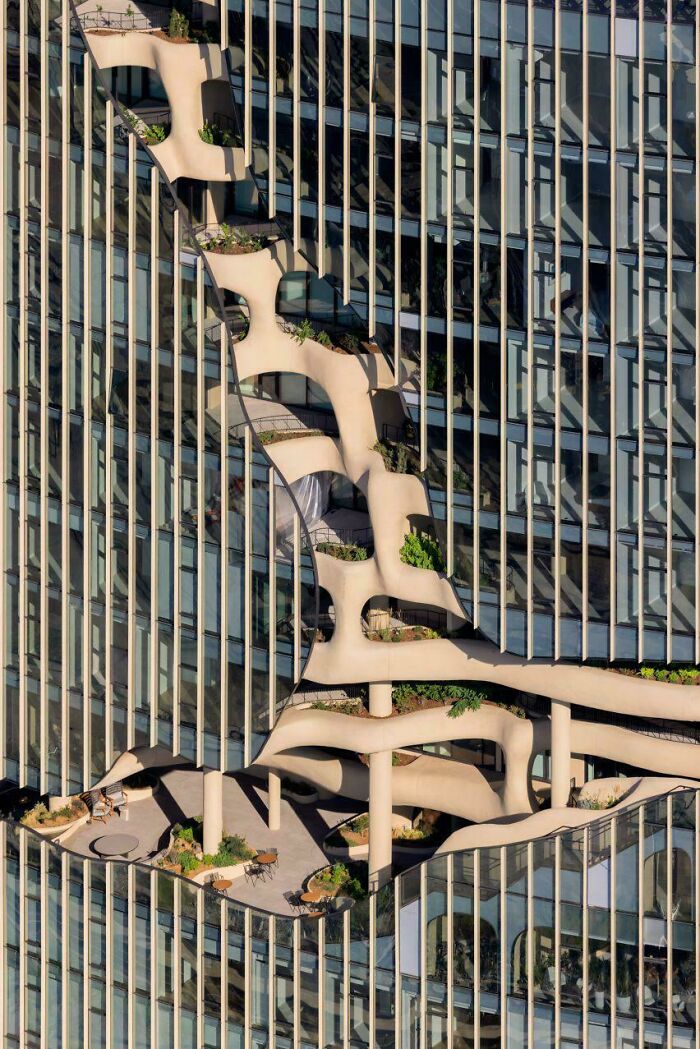 An interesting photo capturing a modern skyscraper with undulating balconies and greenery.