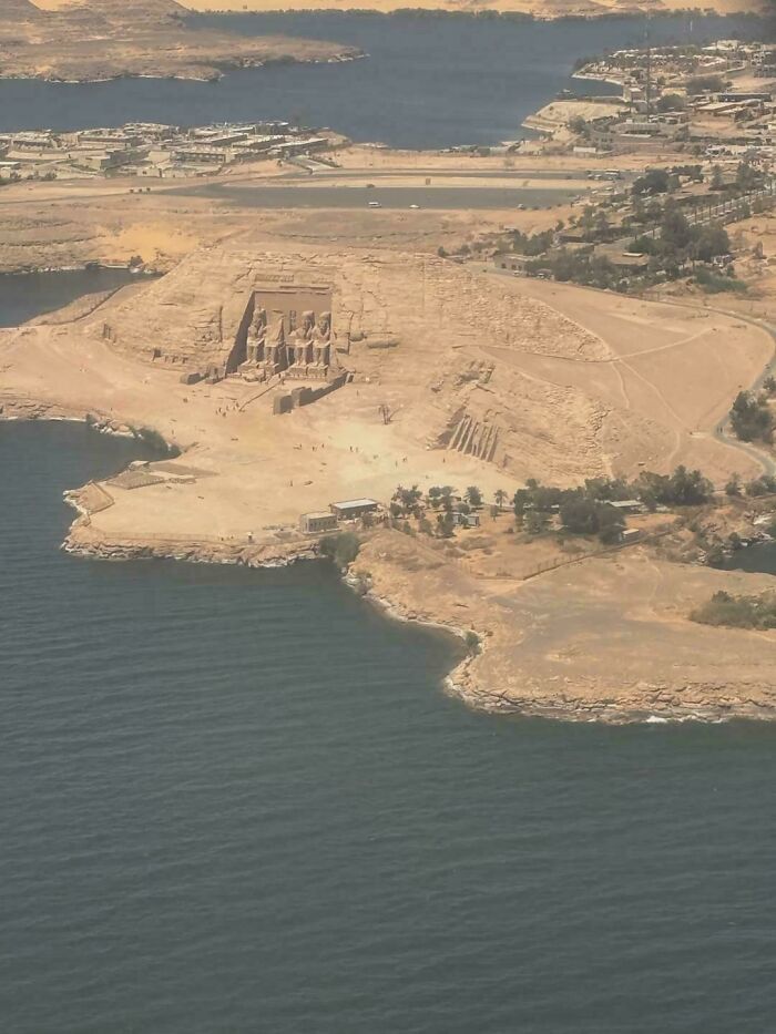 An interesting aerial view of the ancient Abu Simbel temples complex next to a large body of water.