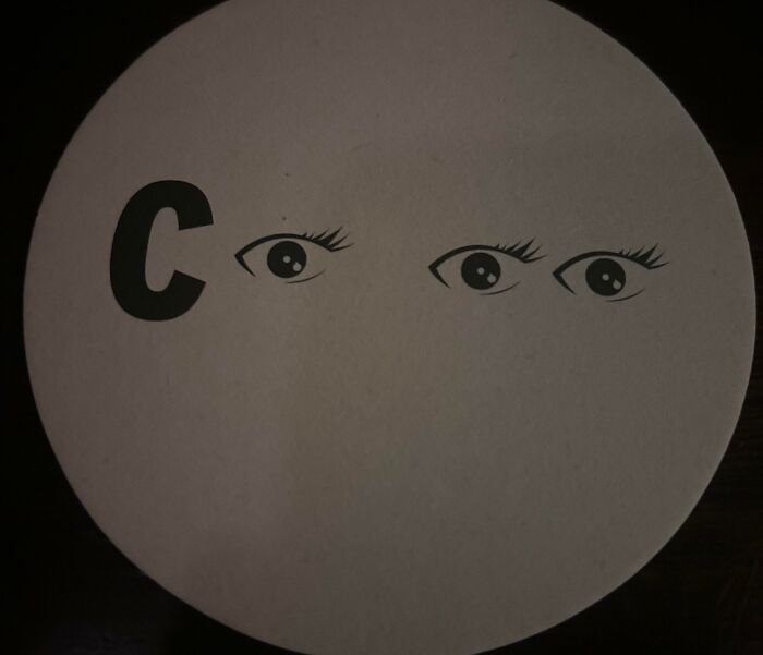A visual brain puzzle displaying a letter C and three pairs of eyes on a circular surface, for confident people.