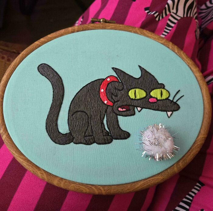 Cartoon cat Snowball II embroidery project in a wooden hoop