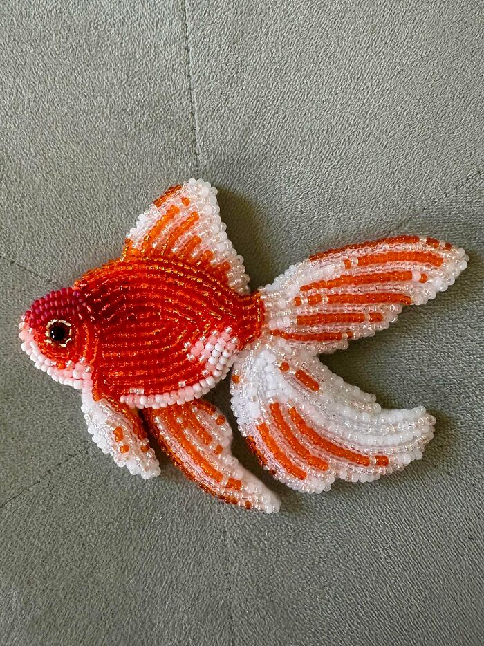 A beautifully beaded goldfish handmade project in orange and white, highlighting the talent and patience in its creation.