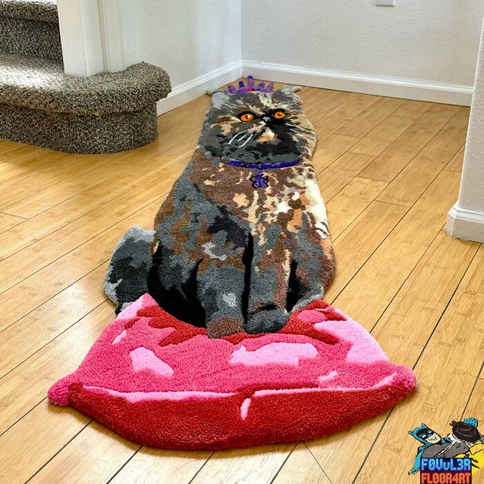 A handmade cat-shaped rug with a crown sitting on a pink lips rug, an imaginative and talented project.