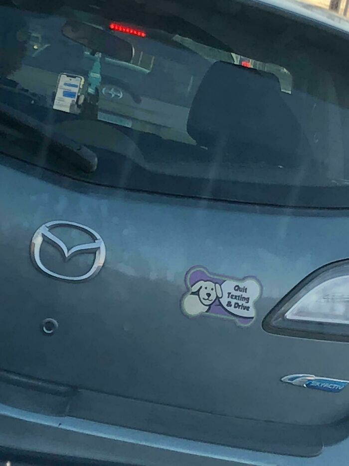 Car with irony bumper sticker saying Quit Texting and Drive