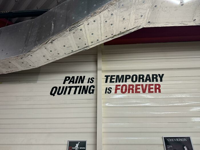 Motivational sign saying pain is quitting, temporary is forever on a wall