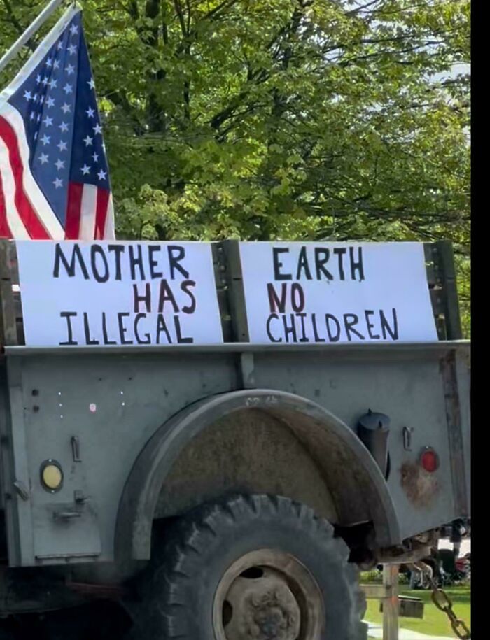 Protest sign stating mother earth has no illegal children on truck