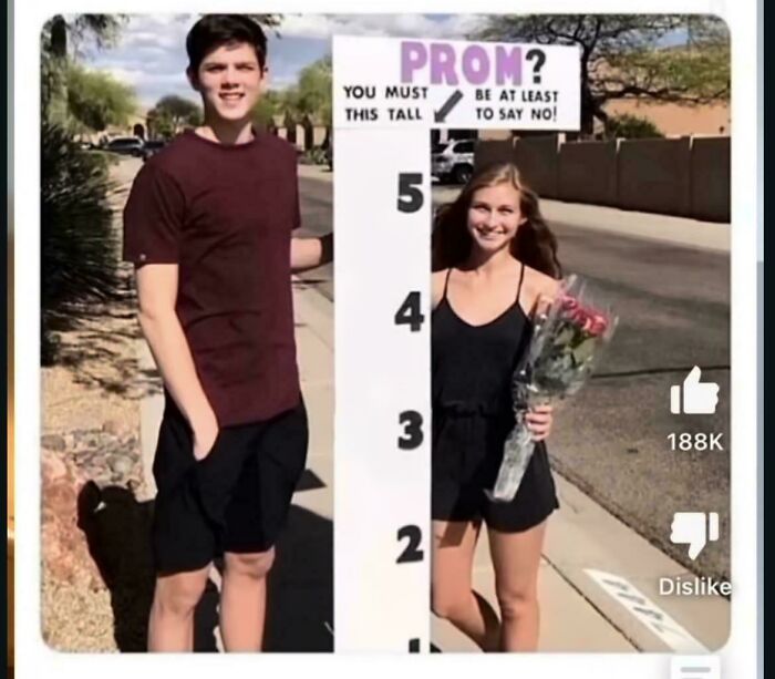 Prom height requirement sign with two teenagers