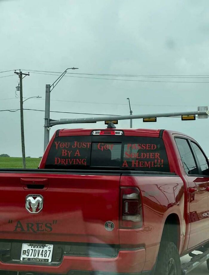 Red pickup truck with humorous sticker about passing a soldier driving a Hemi