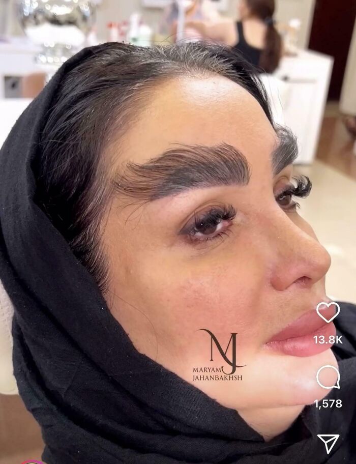 A woman with exaggerated, feathered eyebrows and botched lip fillers from a beauty salon, looking significantly worse.