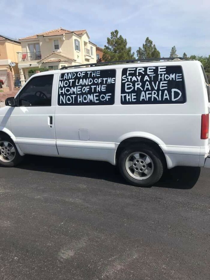 White van with funny handwritten signs about freedom and fear on windows