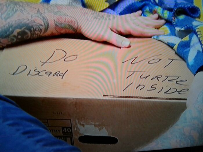 Handwritten cardboard sign warning not to discard or t*****e contents inside