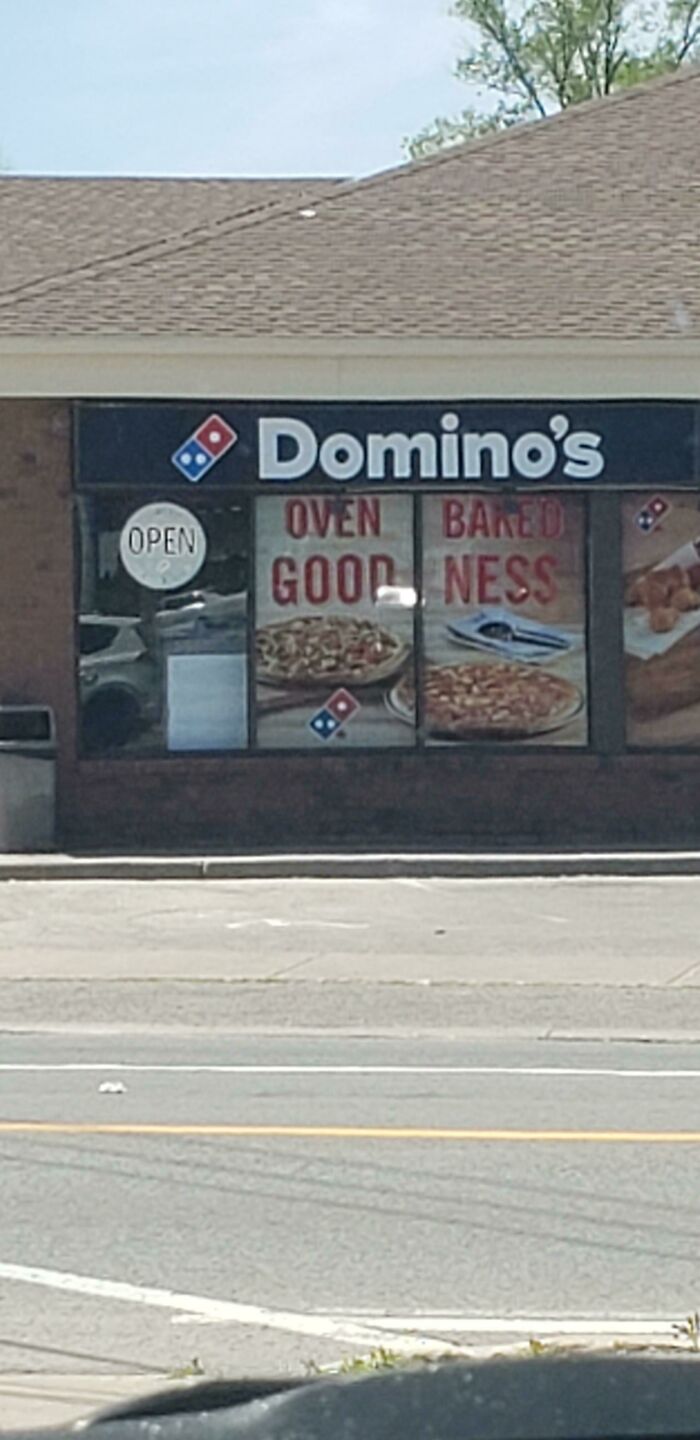 Domino's sign with funny split words oven good baked ness on store window
