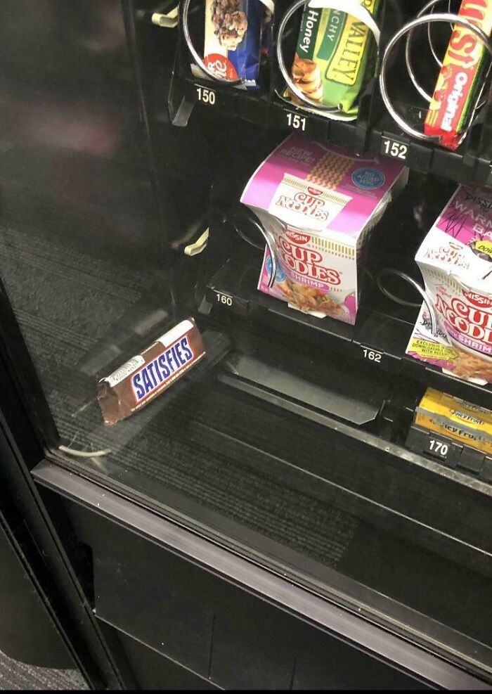 Vending machine snack fallen and blocking the slot below with irony