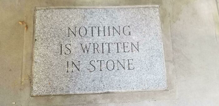 Granite slab with carved words saying nothing is written in stone irony