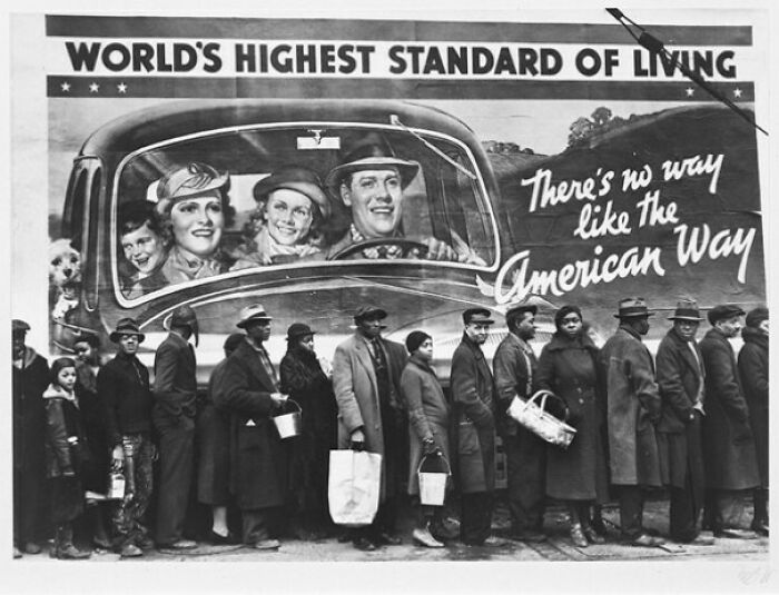 Black and white image of people in line with American way and highest standard of living billboard
