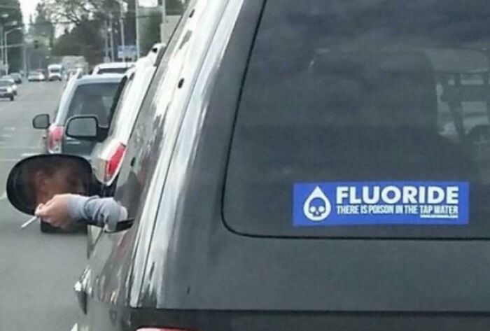Car with anti fluoride poison tap water bumper sticker while smoking out window