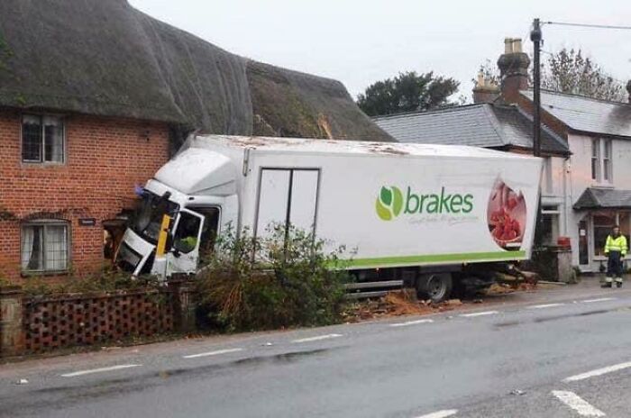 Delivery truck crashes through house roof with brakes logo visible