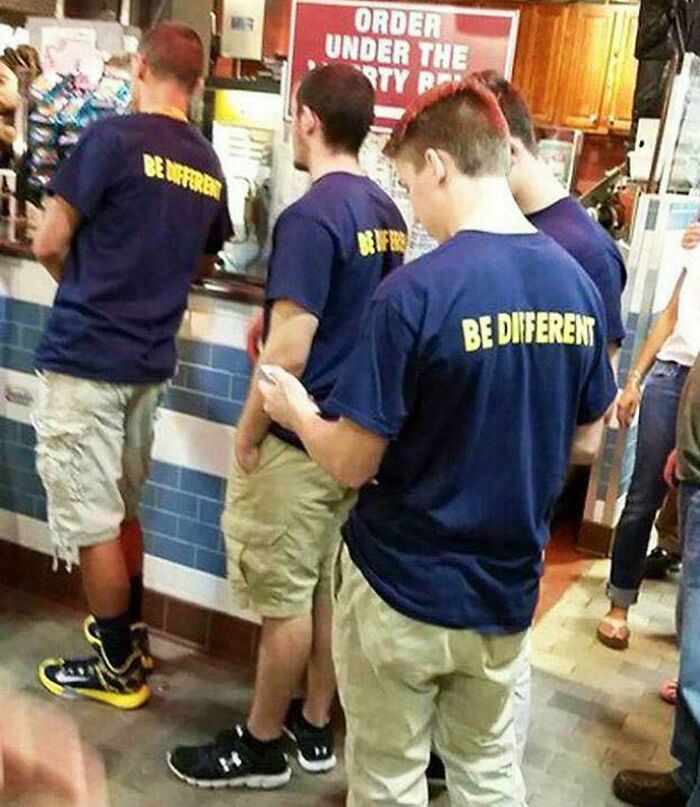 Group all wearing identical be different t-shirts standing in line ironically