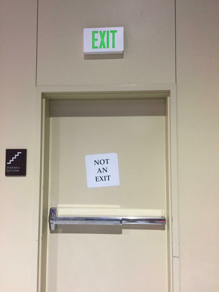 Irony in exit door sign showing exit light with contradictory not an exit paper