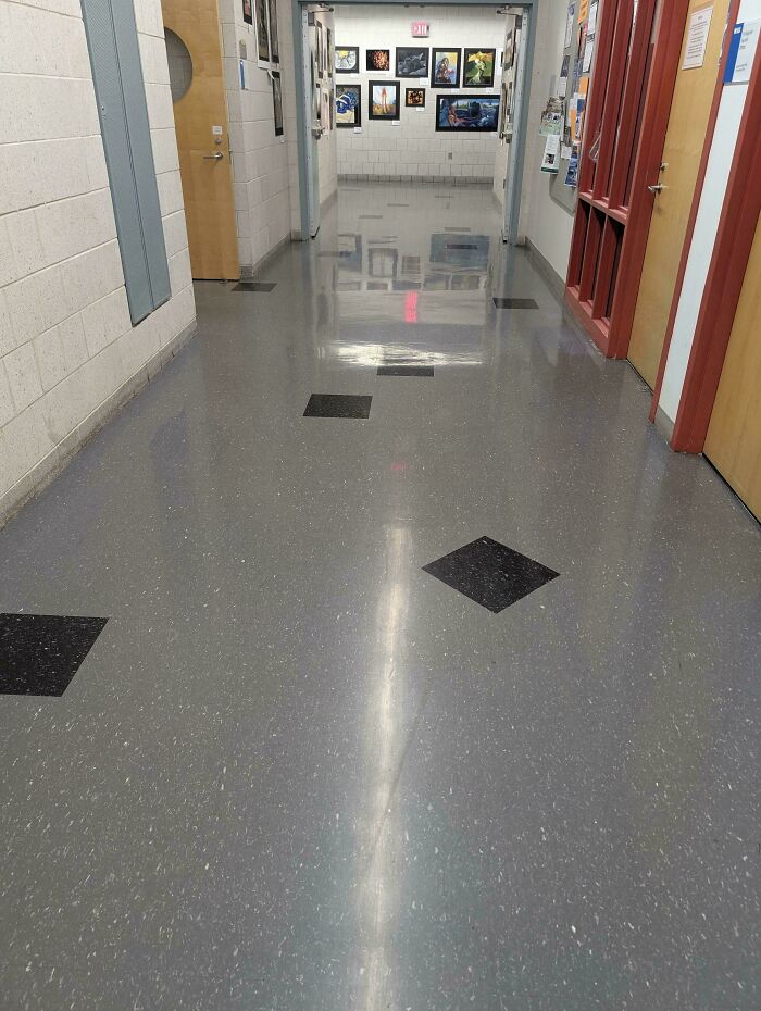 School hallway with confusing tile floor design causing visual distortion