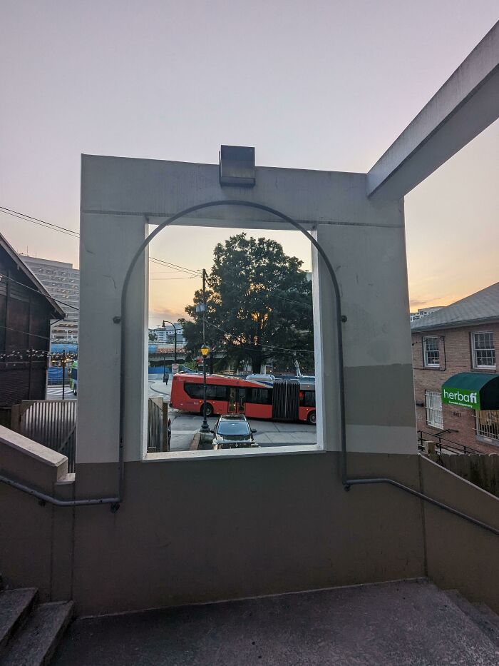 Outdoor archway framing a bus creating a confusing visual perspective fail