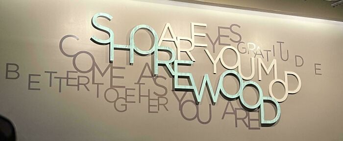 Awkwardly layered wall text with overlapping letters creating confusing design fail