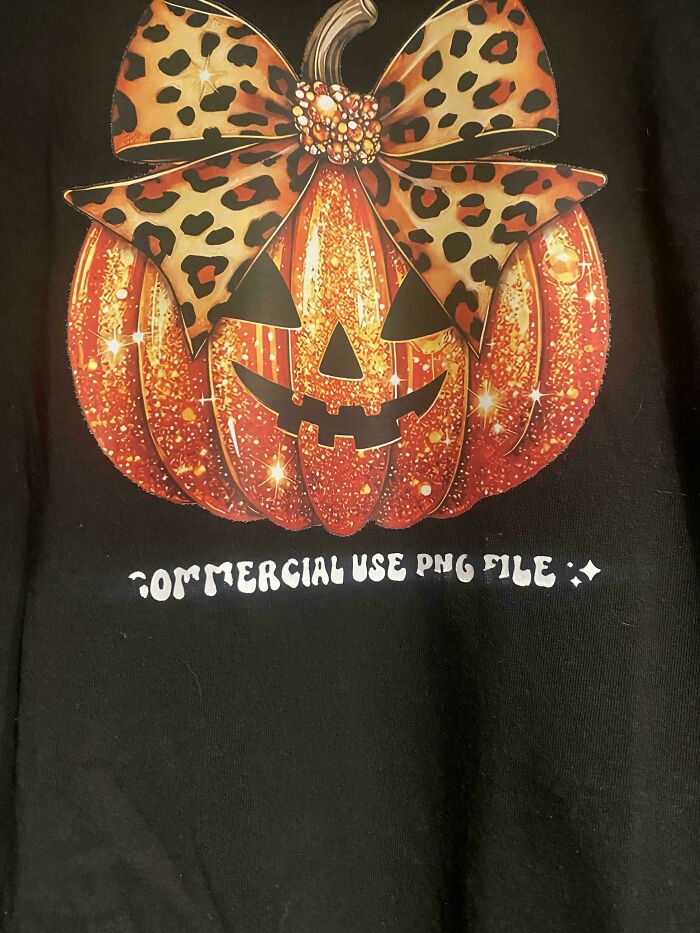 Halloween pumpkin graphic on black shirt with visible commercial use text