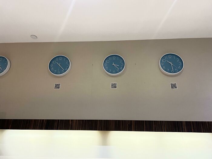 Wall clocks showing different times with mismatched QR codes underneath