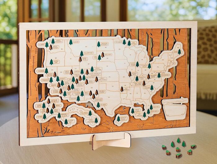Wooden map puzzle of the United States with state markers on table