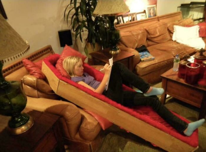 A young woman relaxing in a coffin-shaped lounge chair, showcasing a unique parenting style from her amazing father.