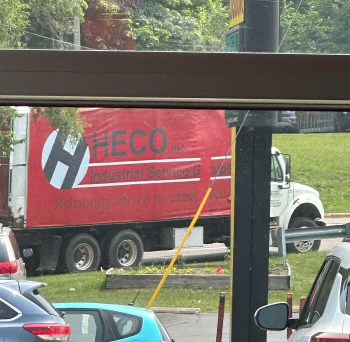 Truck logo obscured and hard to read due to window frame, a branding design fail