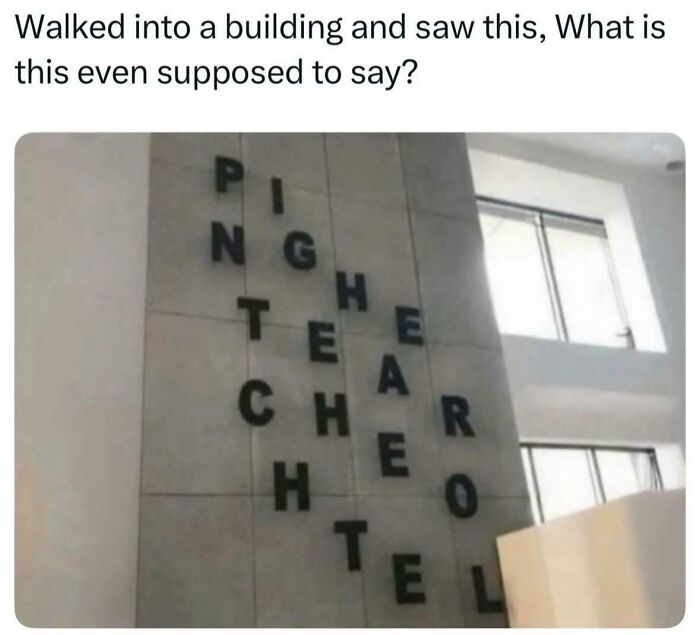 Confusing vertical and horizontal letters on building wall making unclear signage