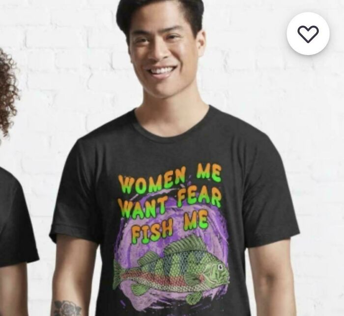 A man wearing a black T-shirt with the text WOMEN ME WANT FEAR FISH ME and a fish graphic, a truly bad clothing design.