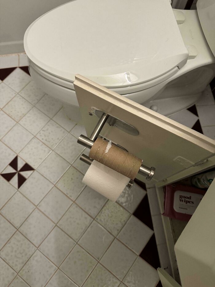 A roll of toilet paper mounted inside a cabinet door, a clever solution for a small bathroom.