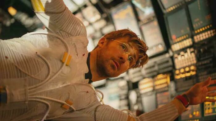 A man in a futuristic white suit with wires, appearing to float, illustrating nonsensical movie details.
