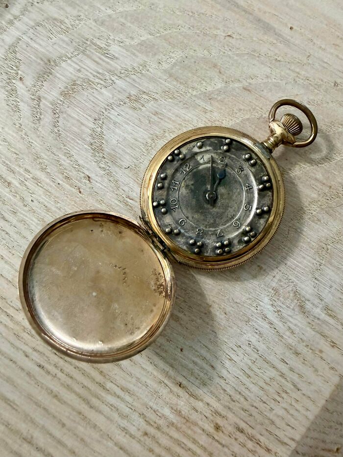Open pocket watch showing raised braille dots on dial as an antique treasure