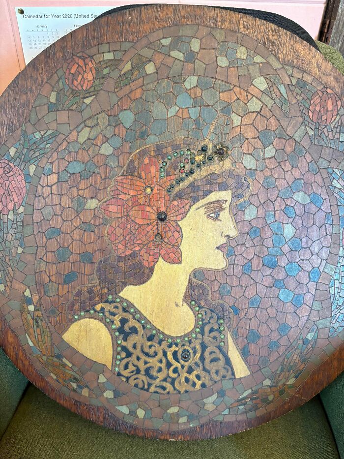 Mosaic wood art featuring a woman profile, prized by antique lovers.
