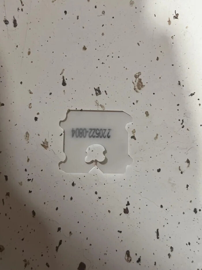A bread clip appears to be a glitch in the matrix, floating in a white, speckled surface.
