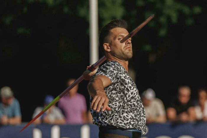 A javelin thrower captured mid-throw creates a visual glitch in the matrix effect as the javelin appears to pierce his head.