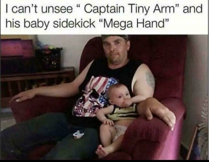 A man sitting with a baby on a red armchair; the mans arm and the babys arm look like a glitch in the matrix.