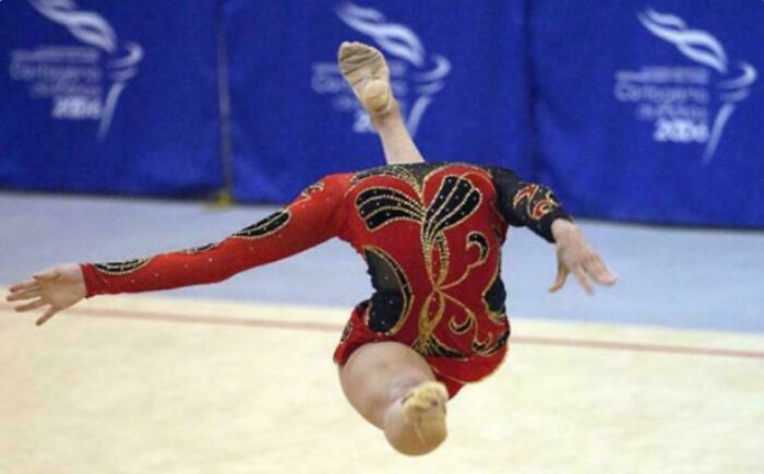 A gymnast performing a complex pose, appearing like a glitch in the matrix with her body twisted.