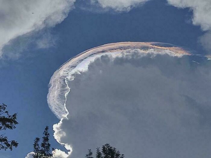 A vibrant rainbow-colored cloud formation in the sky, resembling a Glitch in the Matrix.