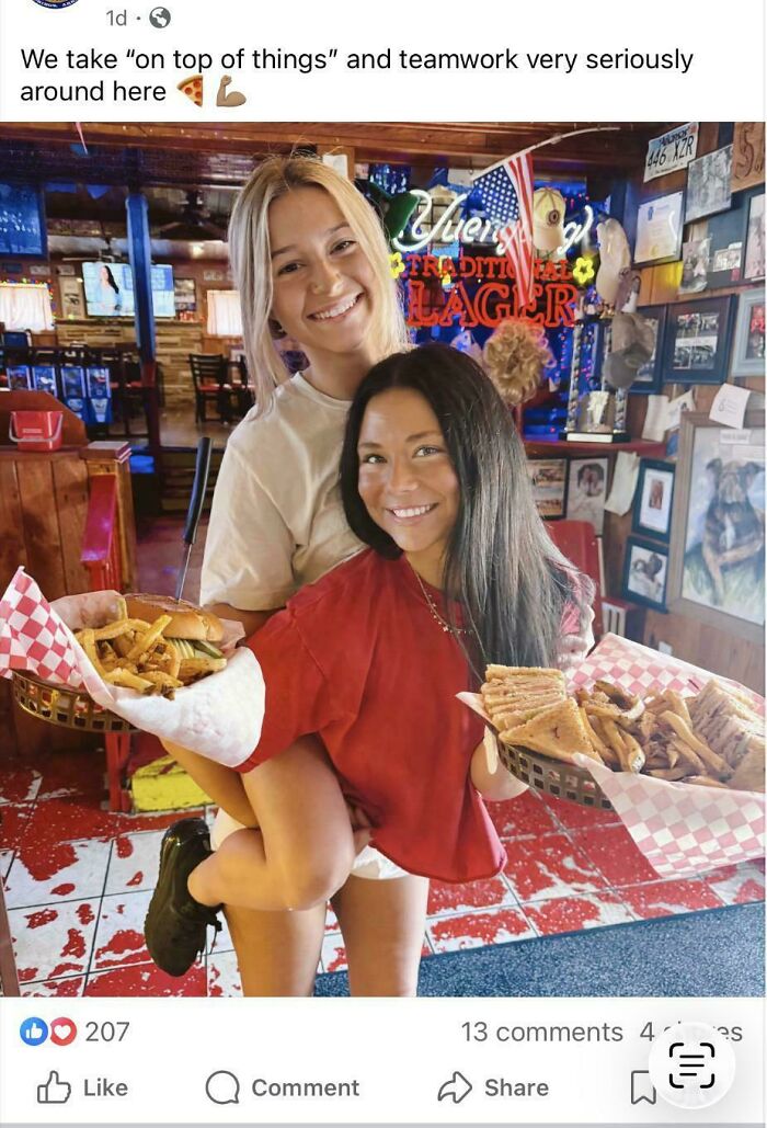 Two happy young women in a restaurant, one carrying the other, both holding baskets of food, a glitch in the Matrix.