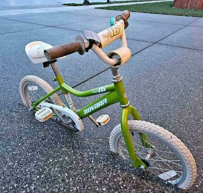 A green bicycle with an unusually short front wheel, a strange sight that looks like a glitch in the matrix.