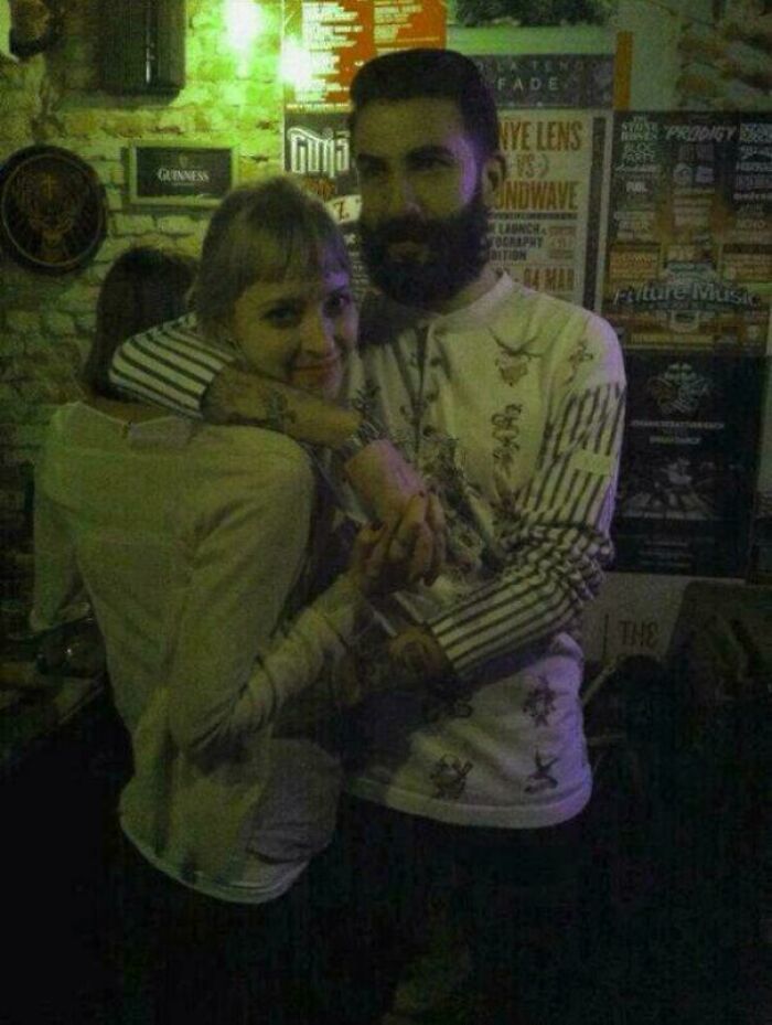 A couple embracing in a dimly lit room, their arms appearing to merge creating a glitch in the matrix illusion.