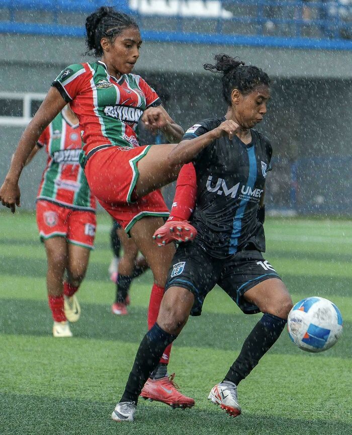 Soccer players in a rainy match, a glitch in the matrix moment with unusual athletic form.