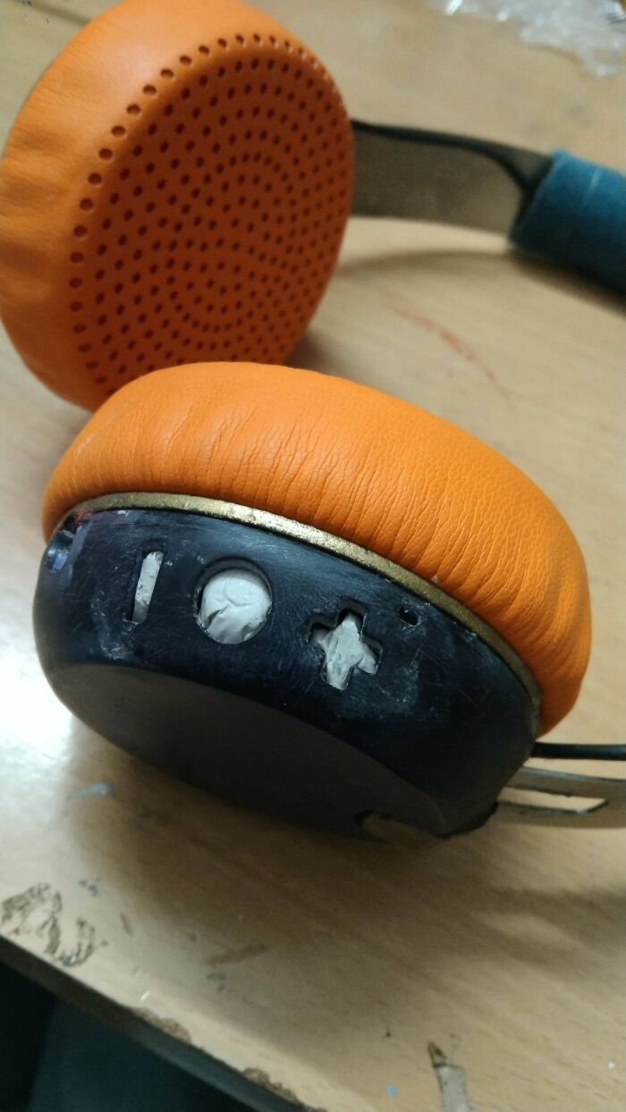 Orange headphones with crude cutouts made as a questionable DIY project modification